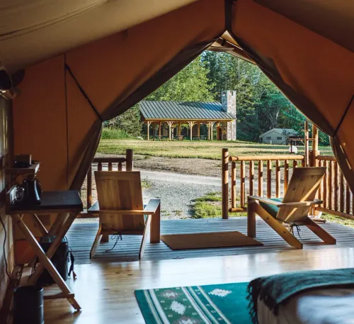 The inside of a glamping tent at Terramor Outdoor Resort in Bar Harbor, Maine, looking out over the grounds
